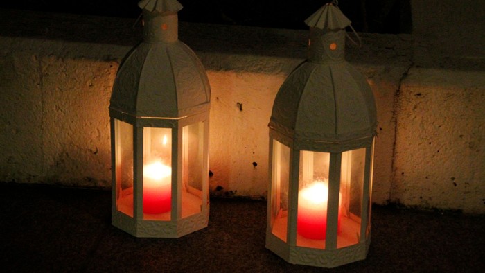 To lamper med røde lys på en mur