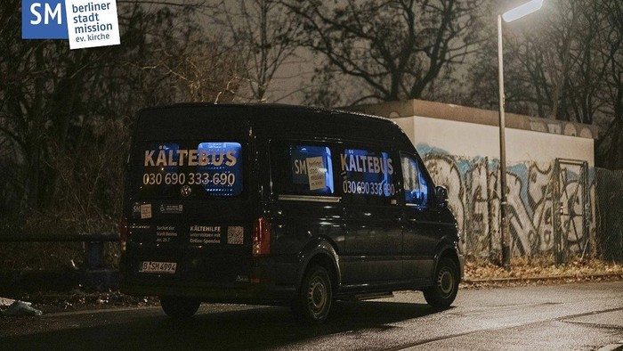 Schwarzer Lieferwagen mit der Aufschrift „Kälteplus“, geparkt auf einer schlecht beleuchteten Stadtstraße bei Nacht mit Graffiti an einer Wand.