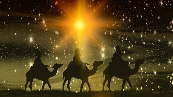 Three wise men on camels under a bright starry sky