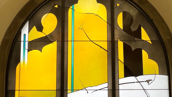 Buntes Kirchenfenster mit abstrakten Formen und gelben Farbtönen