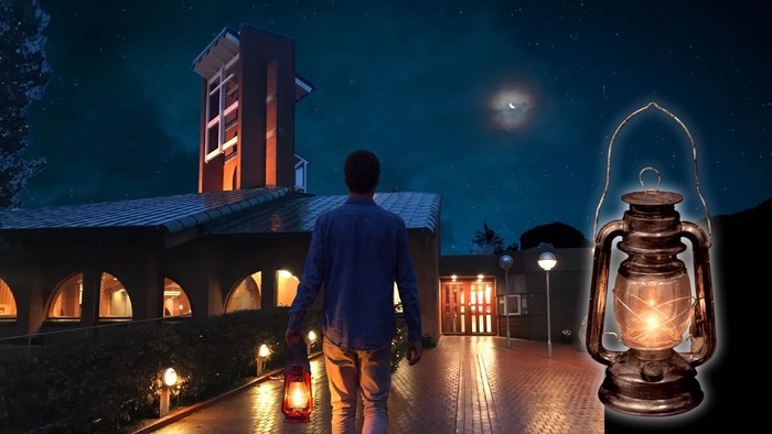 En ensom skikkelse går under en stjerneklar nat mod en svagt oplyst bygning med en lygtebelyst sti.