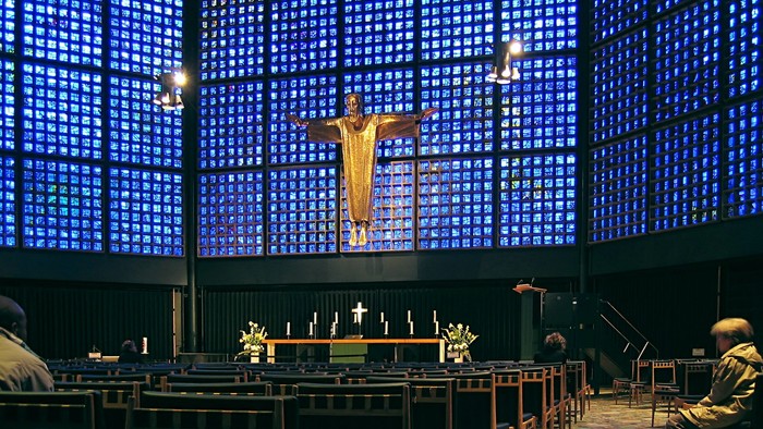 Kirchliche Innenansicht mit Kruzifix und blauen Fenstern