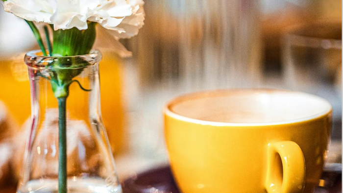 Einladungsplakat für ein kirchliches Sonntagsfrühstück mit Kaffee, Blumen und den angegebenen Terminen.