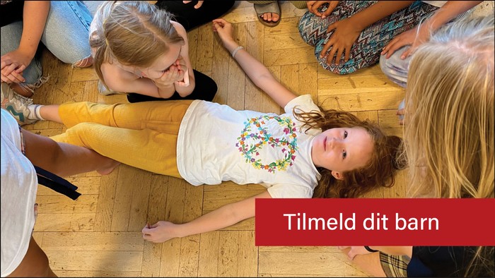 Børn spiller og ler på gulv.
