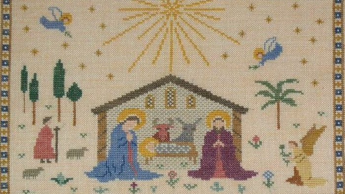 Billedet viser en stitched julekort med en nativity scene og himmelske figurer.