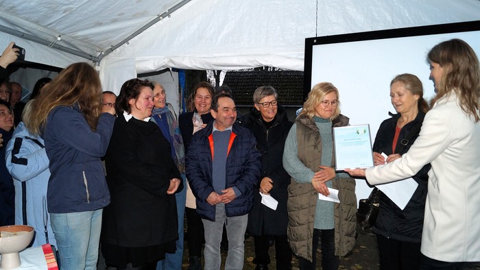 Verena Hammes (ACK-Geschäftsführerin) überreicht den Ökumenepreis an das Team 