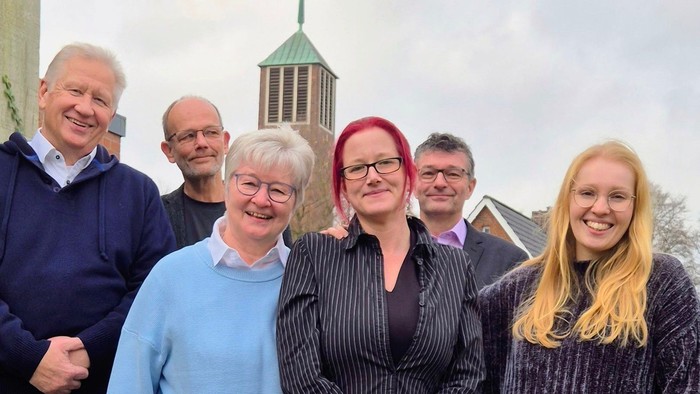 Sechs Menschen von Lichtwark-Forum und Geschäftsführung der Auferstehungskirchengemeinde, im Hintergrund der Kirchturm der Auferstehungskirche 