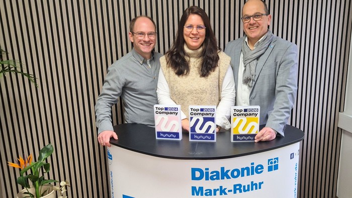Freuen sich stellvertretend für alle Gesellschaften unter dem Dach der Diakonie Mark-Ruhr über die erneute Auszeichnung mit dem Top-Company-Siegel, von rechts: Pfarrer Matthias Börner (Geschäftsführung Diakonie Mark-Ruhr), Theresa Touloupis (Leitung Kommu