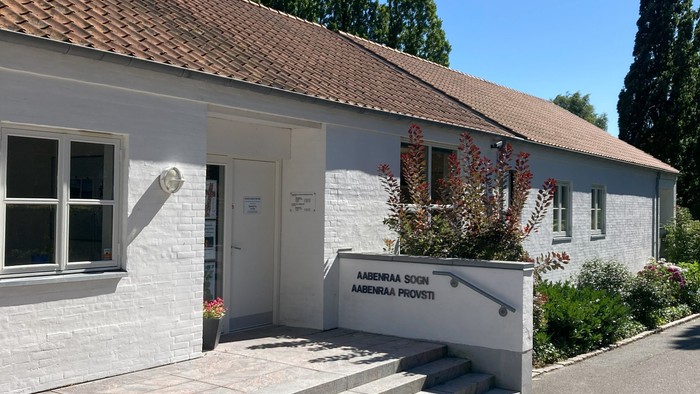 Det er et lille, hvide hus med trætag og en trappe op til indgangen.