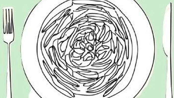 En tallerken med spiralnudler med en gaffel ved siden af.