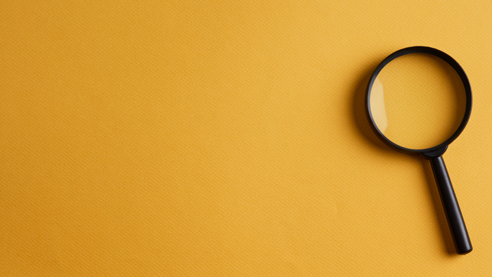 Eine Lupe auf gelbem Untergrund