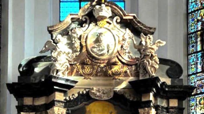 Udarbejdet alter med religiøs kunst, farvede glasvinduer og prangende gylden solstråleudsmykning ovenover.