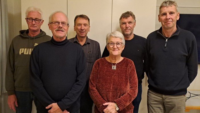 En gruppe af seks personer står sammen i et rum