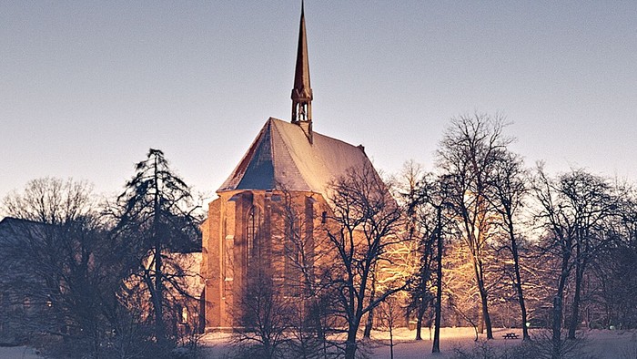 Schneebedeckte Landschaft mit Kirche im Hintergrund