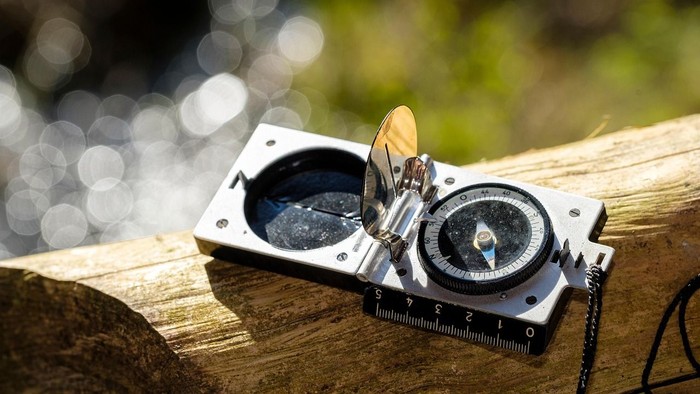 Bild mit dem Thema Maßstab und Orientierung. Wanderkompass in der Natur