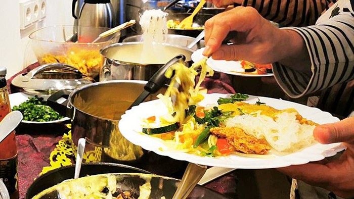 Menschen bedienen sich an einem Buffet mit verschiedenen Gerichten