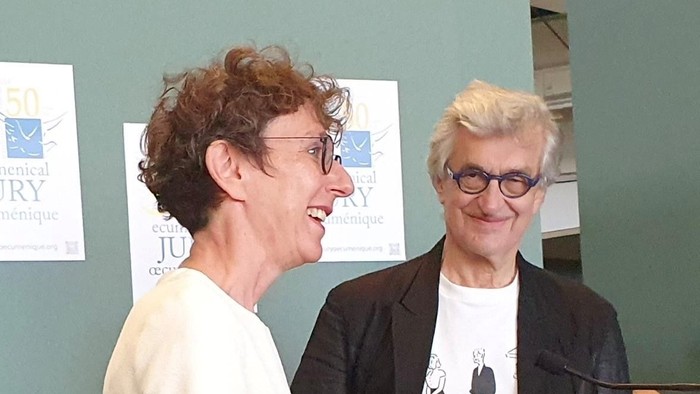 Wim Wenders und Julia Helmke lächeln ins Publikum.