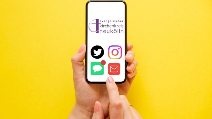 Hände halten ein Smartphone, das Social-Media-Symbole und das Logo einer evangelischen Kirche aus Neukölln anzeigt.
