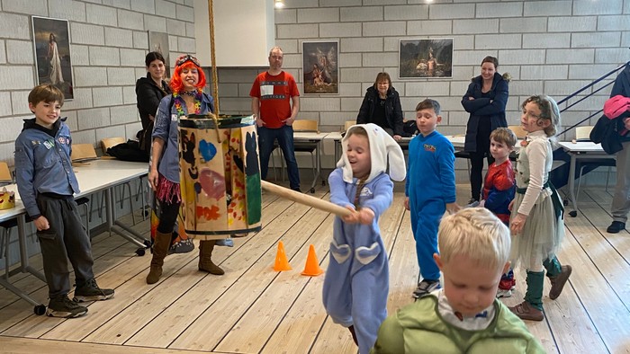 Børn, der leger i et rummeligt rum, mens voksne observerer.