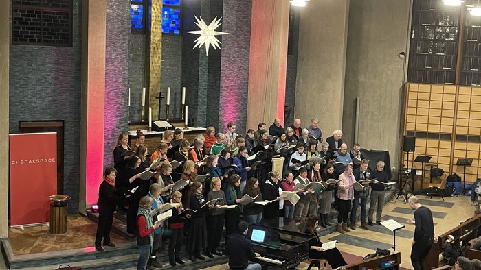 Viele Menschen singen im Chor unter einem Stern in der Gustav-Adolf-Kirche.