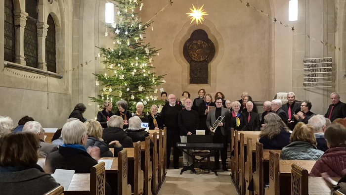 Ein Bild aus der Johanneskirche, man sieht links den geschmückten Tannenbaum und alle Ausführenden Musiker beim Schlussapplaus.