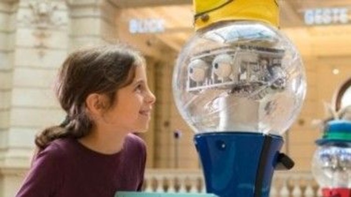 Kind erkundet einen Roboter im Museum.