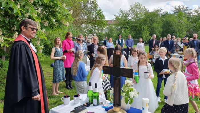 Eine Hochzeitszeremonie im Freien mit einem Priester, der Braut und den Gästen.