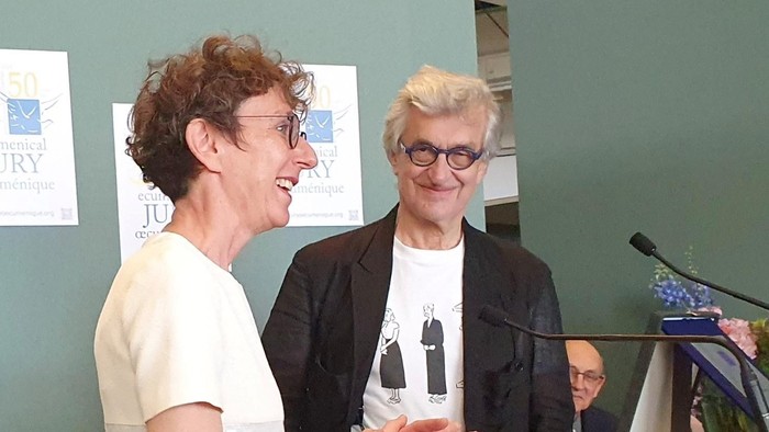 Wim Wenders und Julia Helmke lächeln ins Publikum.