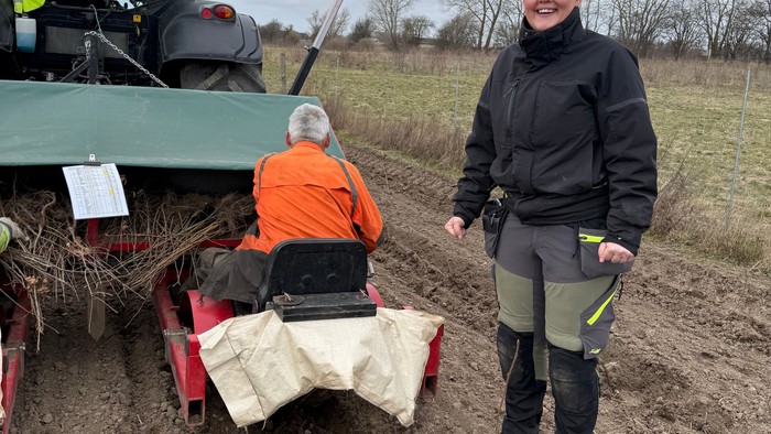 en mand sidder på en maskine og planter træer