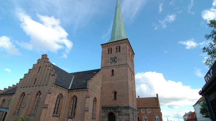 En kirke med tårn og spiret mod himlen