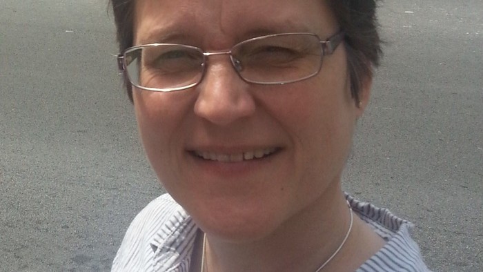 Kvinde med briller og kort hår.