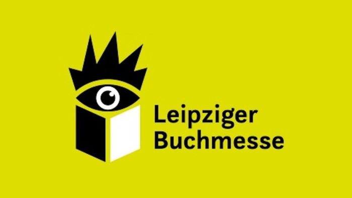 Logo für die Leipziger Buchmesse, das ein aus einem Buch blickendes Auge mit einer Krone zeigt, vor einem gelben Hintergrund.