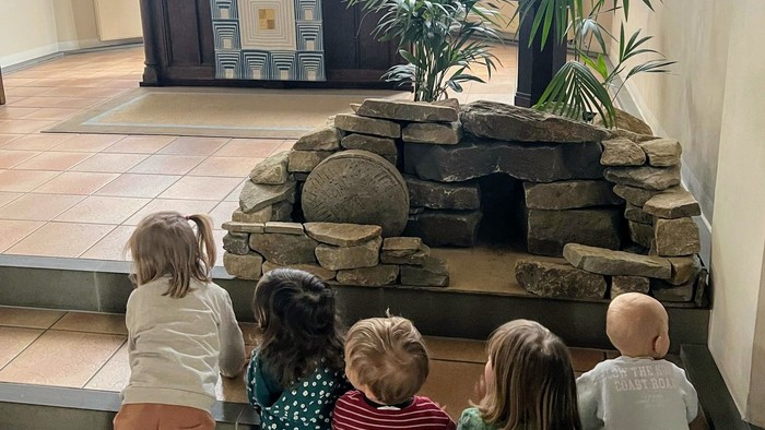 Kinder der Kita sitzen vor dem Altar