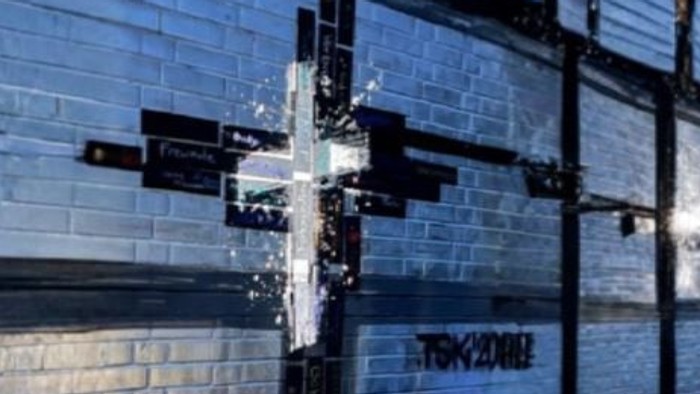 Grafitti-Kreuz vor einer Klinkerfassade