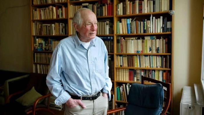 Zu sehen ist Pfarrer Jürgen Wehrmann in seinem Büro zuhause, vor einem Bücherregal