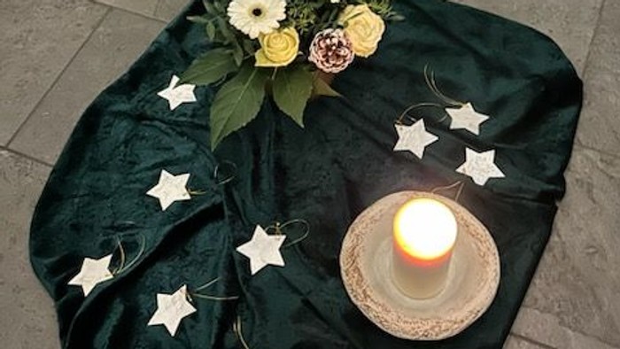 Kerze, Blumen, Sterne auf einem Tuch