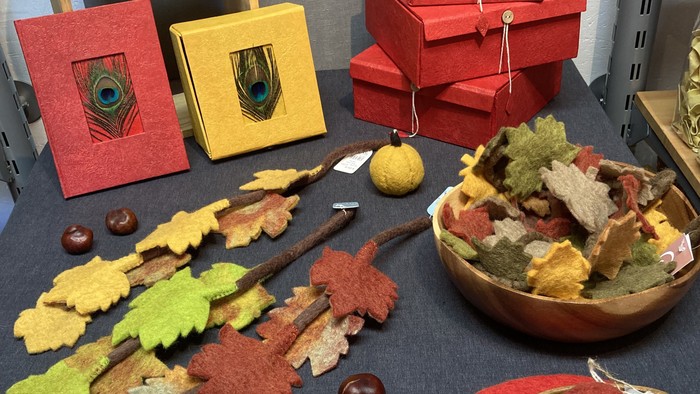 Herbstliche Dekorationsartikel, darunter Holzschalen, blattförmige Kekse und Pfauen-Dosenbastelarbeiten.