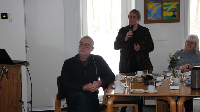 Ellen fortæller i mikrofon, mens Hans sidder foran og kigger op