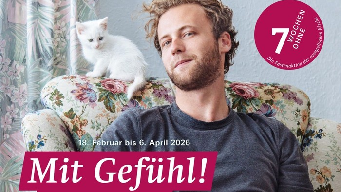 Ein Mann sitzt mit einer Katze in einem blumigen Sessel und wirbt für die Ausstellung *„Sieben Wochen ohne Härte“*.