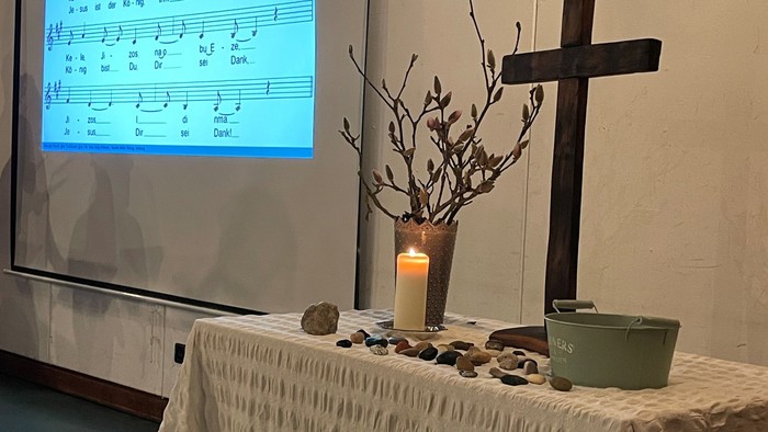 Altar mit Licht, Kreuz und Steinen
