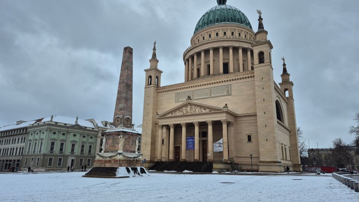 Große Kathedrale mit einer mächtigen Kuppel thront majestätisch auf einem schneebedeckten Platz.