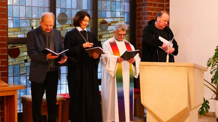 Religiöse Führer in Roben und Messgewändern, die während eines Gottesdienstes aus Büchern vorlesen.