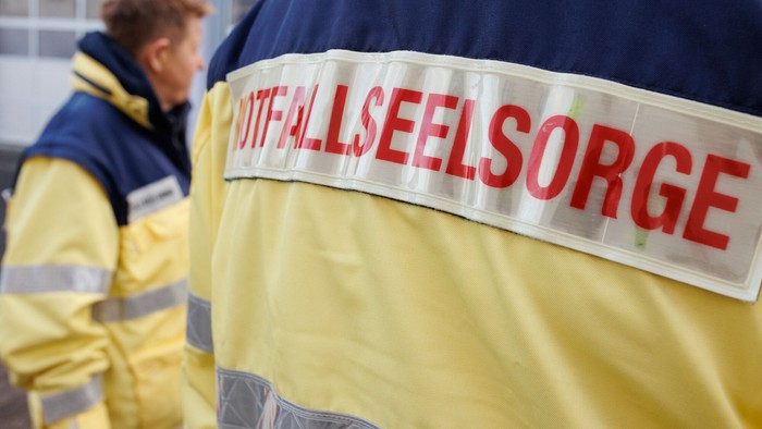 Zwei Personen in gelben Warnwesten mit Aufdruck