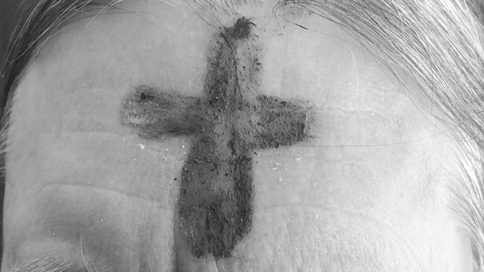 En person med et tatovering af et kors på nakken.