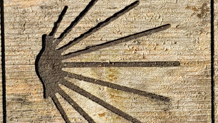 Das Bild zeigt ein abstraktes Kunstwerk auf Holz mit einem sternförmigen Muster.