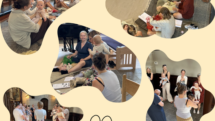 En glad gruppe deltager i babymassage og samværsaktiviteter i et fællesskabsmiljø.