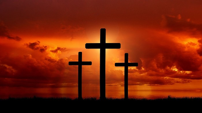 Three crosses against a sunset sky