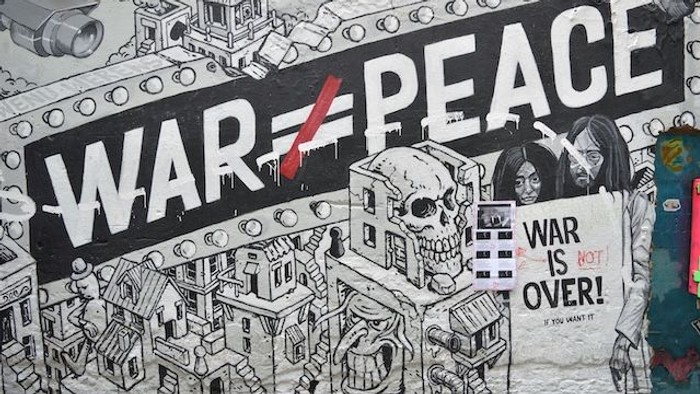 Graffiti-Wandbild, das die Verwüstung des Krieges darstellt, mit Slogans gegen Konflikte und Gewalt.