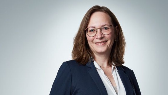 En professionel kvinde i blå jakke og hvid skjorte.