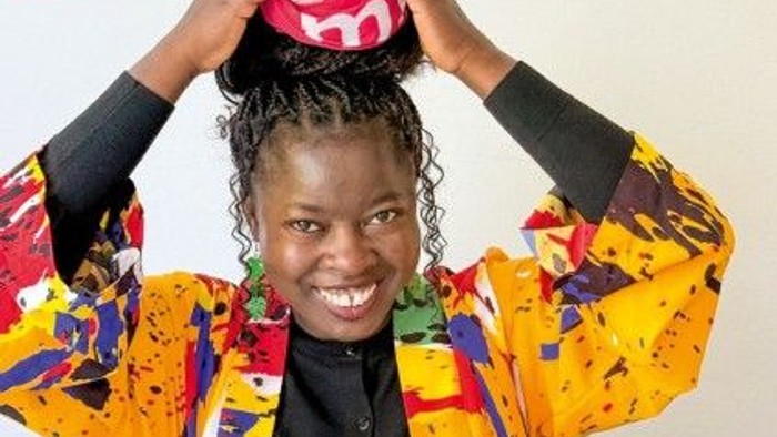 Eine Frau aus Nigeria hält ihre Hände über dem Kopf.